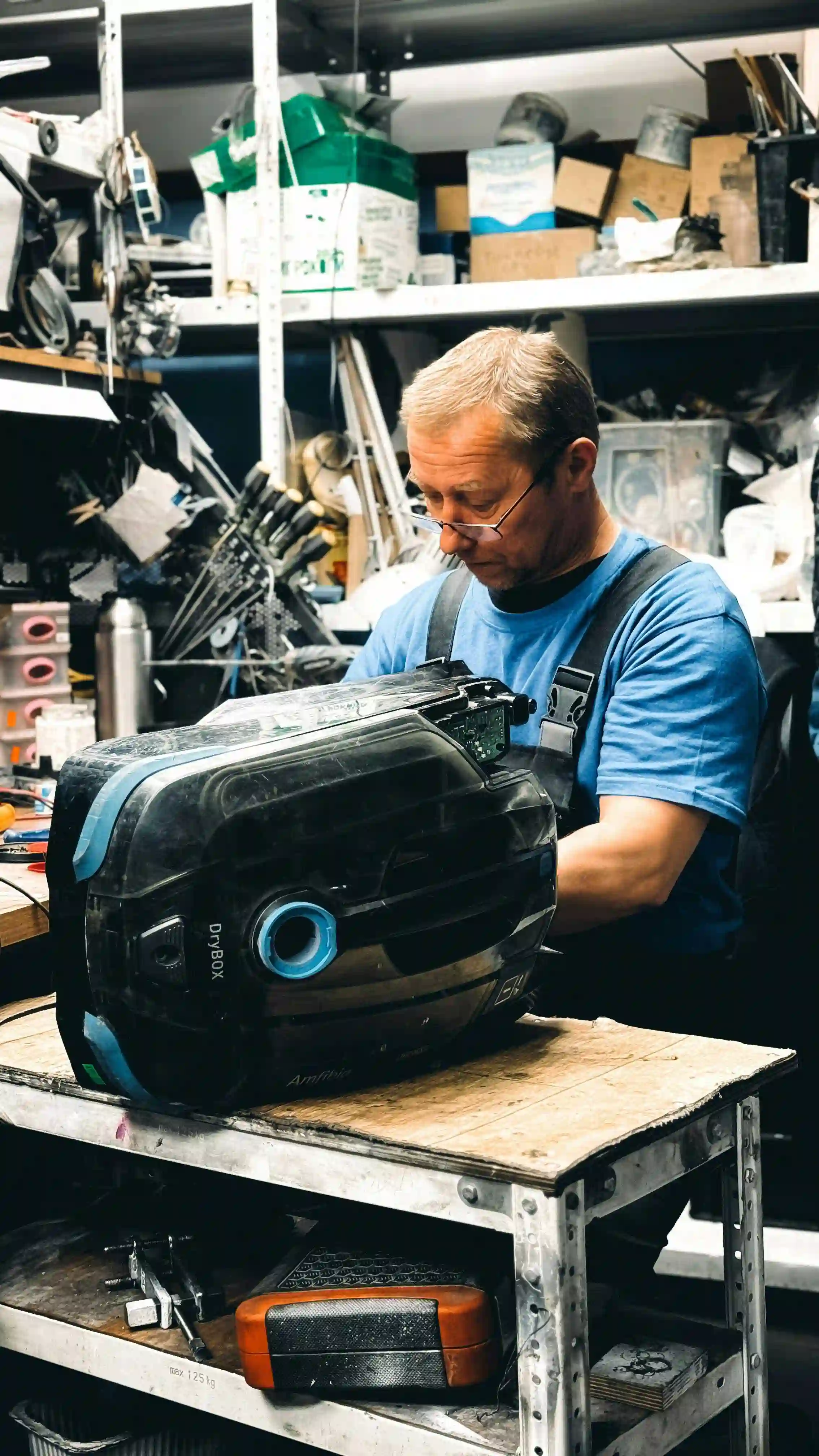 Мастер чинит пылесос.